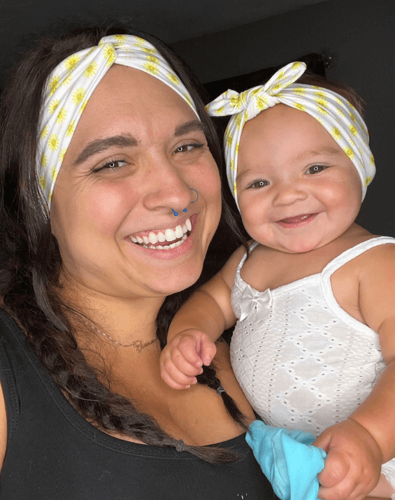 Mom and baby girl are wearing matching mommy and me head wraps from By Bella Boutique.