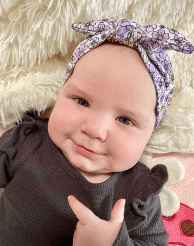 Baby girl is wearing a baby headband for little girls from By Bella Boutique.