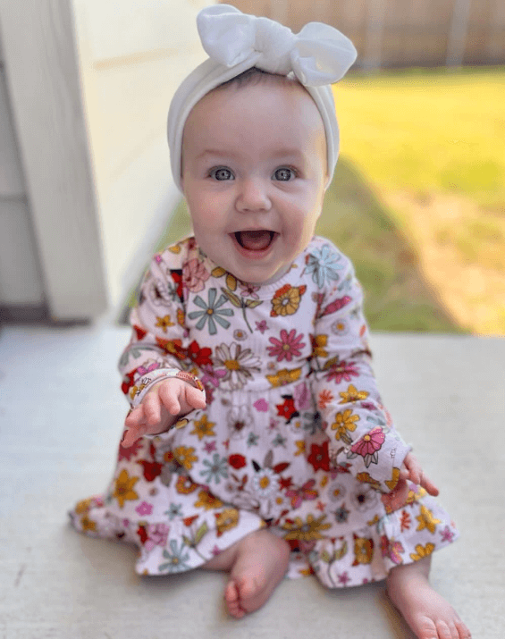 Baby girl is wearing a velvet headband for little girls from By Bella Boutique.