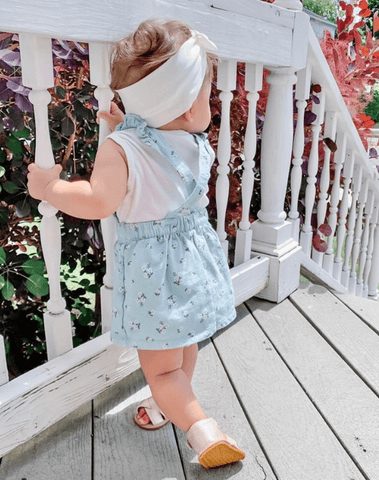 Little girl is wearing the most comfortable baby head wrap from By Bella Boutique.